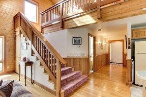 A wooden interior with a staircase, a kitchen area, and a living room with a couch. - Cute Cottage with Close Beach Access & Free WiFi - Dogs Welcome (Cannon Beach)