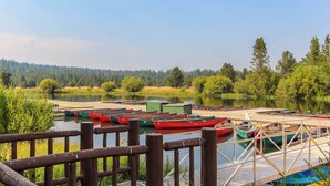 Un molo sul lago con canoe e una ringhiera di legno.