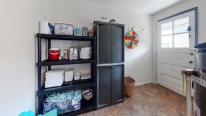 Una cocina compacta con un armario negro, piso de baldosas y una puerta con ventanal.