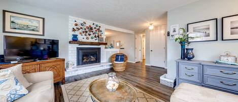 A living room with a fireplace, a television, and a coffee table.