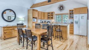 A spacious kitchen with wooden cabinets, a central island, and a large window. - Spacious dog friendly home withprivate hot tub, guest bikes, (Sunriver)