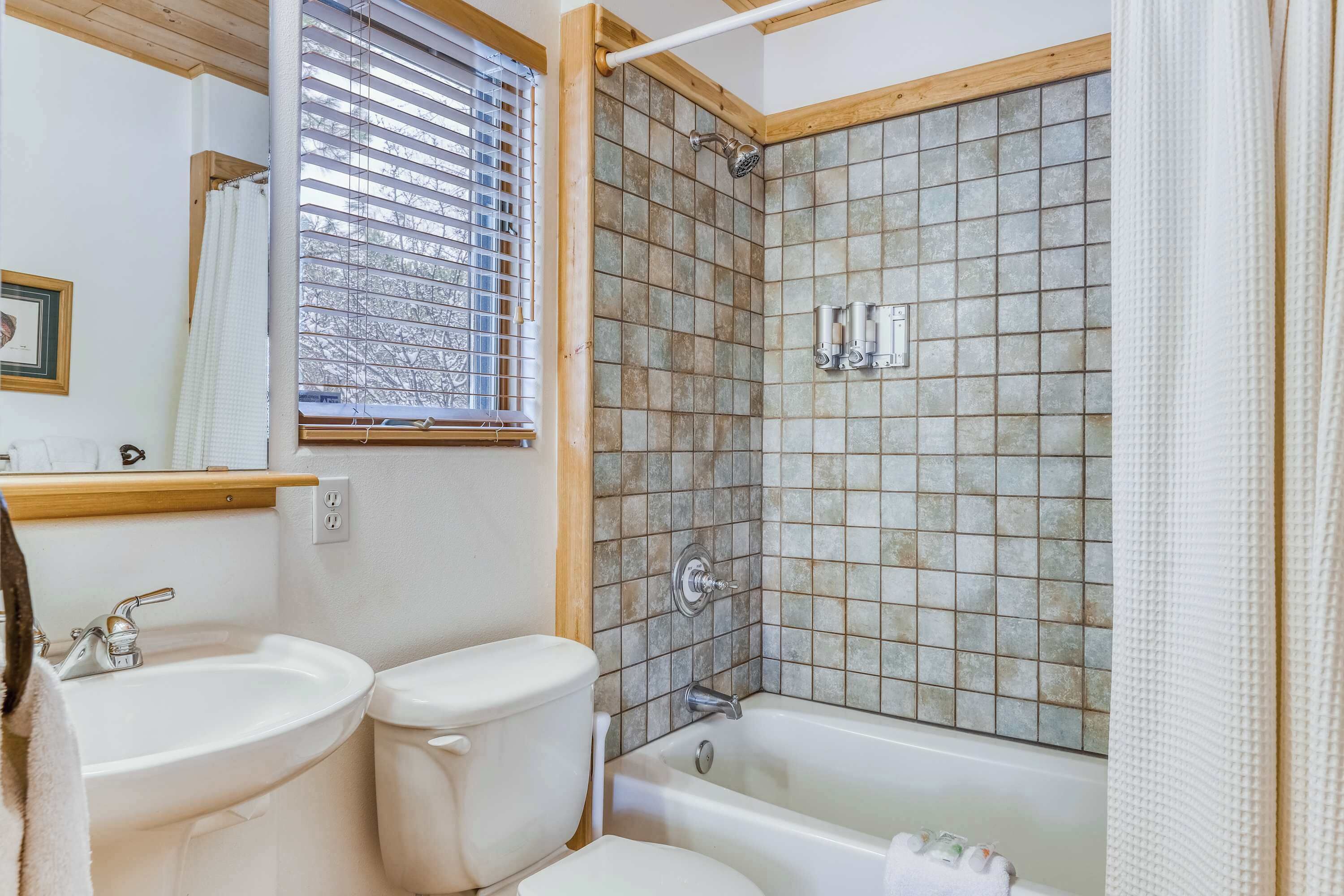 A bathroom with two sinks, a toilet, a bathtub, and a shower with tiled walls.