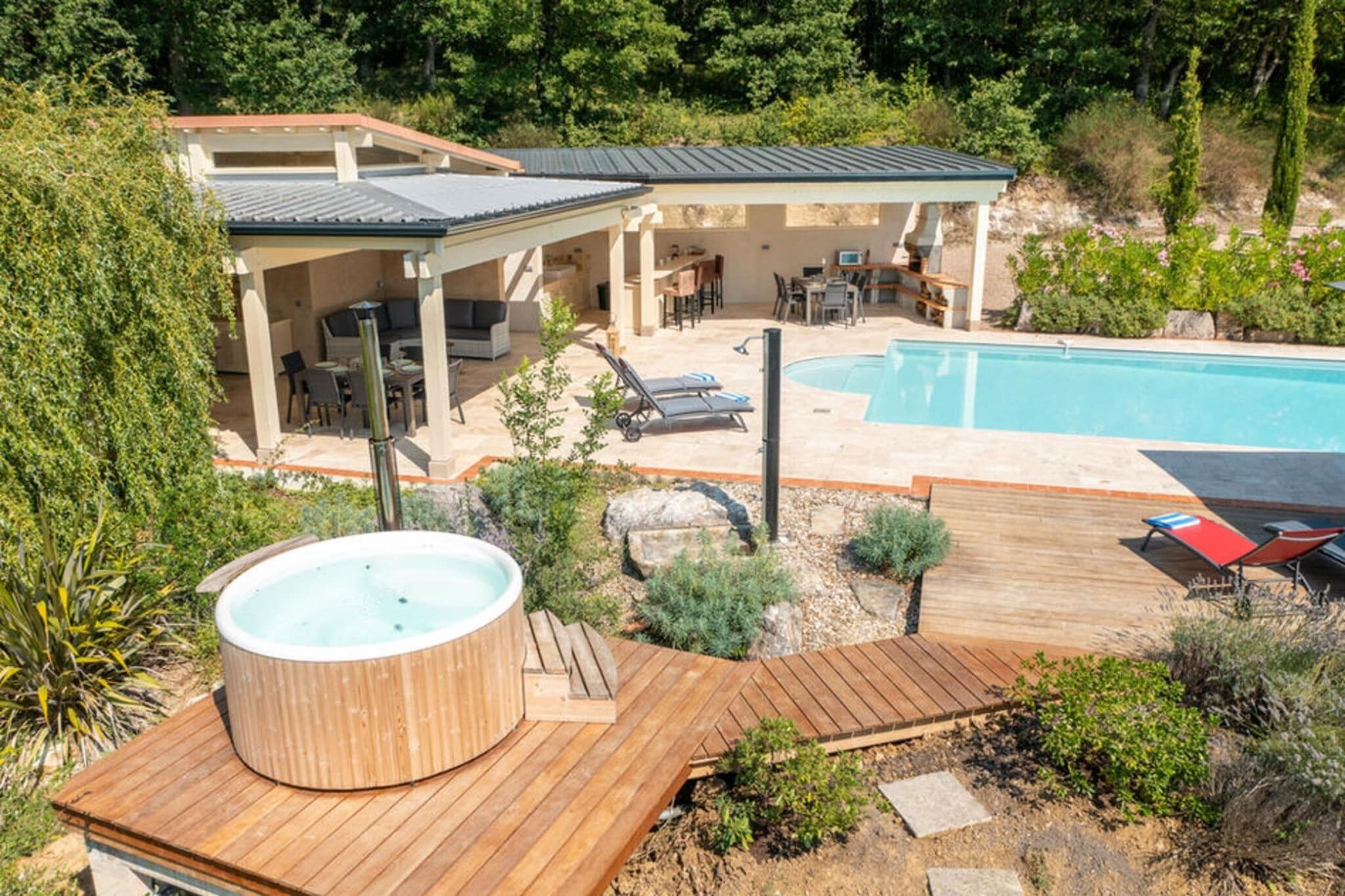 Een achtertuin met een zwembad, een jacuzzi en een overdekt terras.
