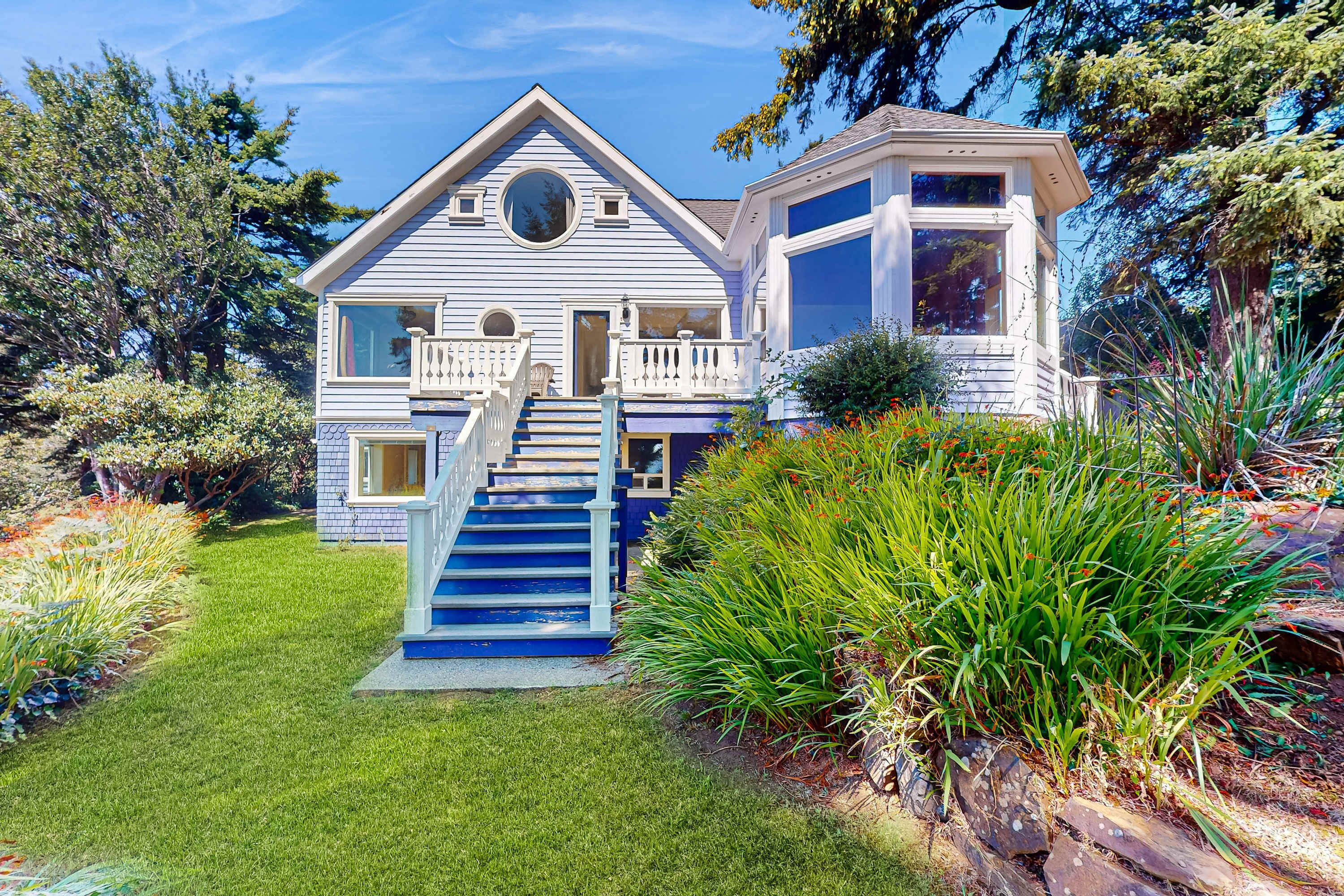 A house with a blue exterior, a front porch, and a staircase leading to the entrance.