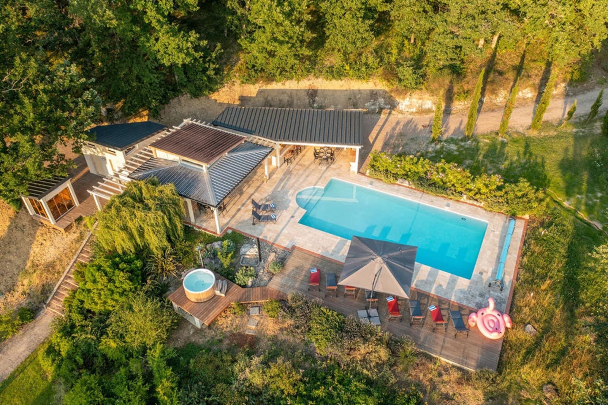 Ein Luftbild eines Anwesens mit Schwimmbad, Sitzgelegenheiten im Freien und Whirlpool.