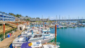 A marina with boats docked, a pier, and a building with balconies. - Waterfront Condo with Private Deck, Bay Views, Pool, Hot Tub, & Sauna (Newport)
