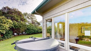 Un jacuzzi en el exterior de una casa con vistas al jardín y un patio.
