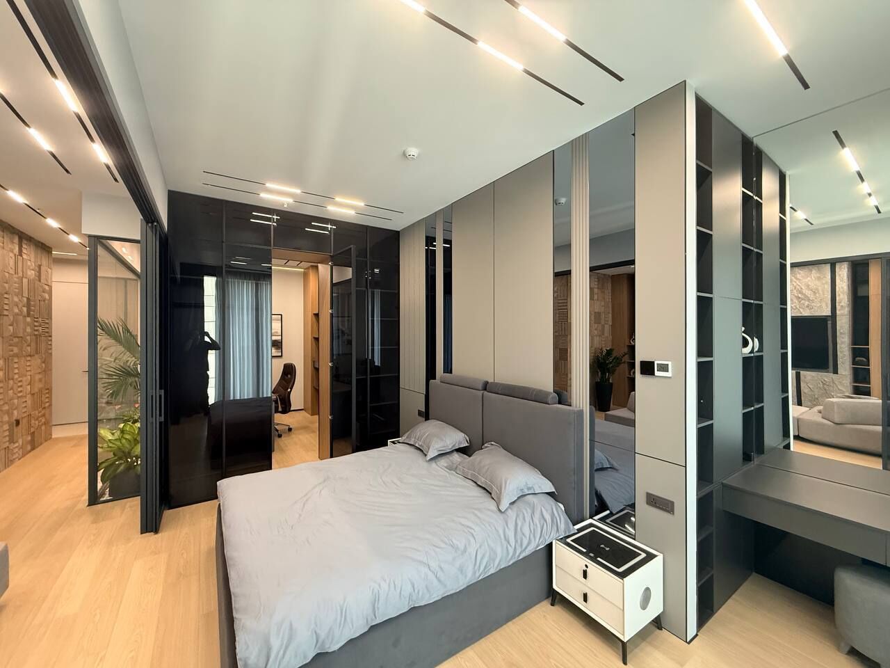 Een moderne slaapkamer met een bed, een inbouwkast en een bureau.