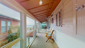 A corridor with large windows, wooden flooring, and a ceiling with exposed beams. - Oceanfront home with private hot tub, walls of glass & spectacular view (Brookings)