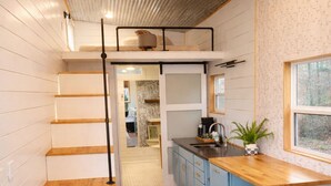 Un intérieur moderne comprenant un escalier, un coin cuisine et un espace salon.