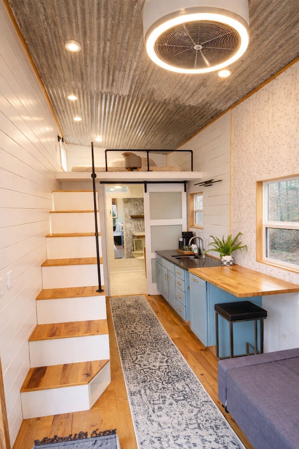 Ein modernes Interieur mit Treppe, Küchenbereich und Sitzecke.