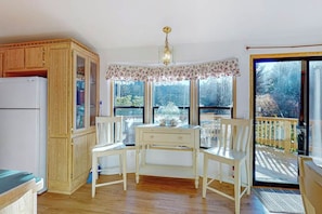 Una cocina con armarios de madera, un refrigerador blanco y una mesa de comedor con sillas.