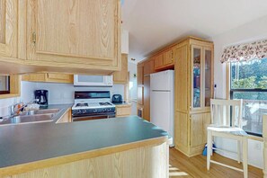 A kitchen with wooden cabinets, a microwave, a stove, and a refrigerator.