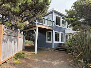 A two-story house with a covered porch and a fenced yard.