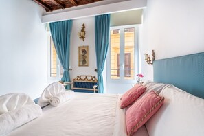Habitación de hotel con cama, un banco y vistas al exterior.