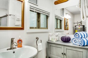 A bathroom with a sink, mirror, towel rack, and a window with blinds. - Single-level home with firepit & gas fireplace - walk to the beach, 3 dogs OK (Ocean Park)