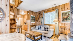 Un interior de madera con un sofá, una mesa de centro y una chimenea.