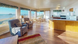 A spacious living area with a sofa, dining table, and kitchen area.