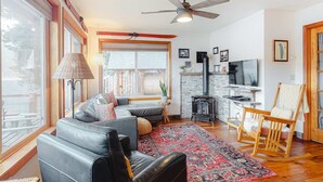 A living room with a sofa, a rocking chair, a fireplace, and a television.
