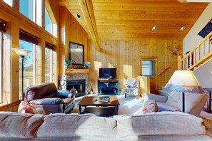 Ein Holzinnenraum mit Kamin, Fernseher und einer Sitzecke.