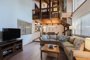 A modern living room with a television, sofa, and wooden coffee table. - Inviting condo with private sauna & wonderful shared amenities (Sunriver)