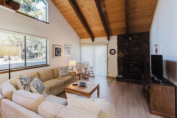 A cozy living room with a sofa, a coffee table, and a fireplace. - Inviting condo with private sauna & wonderful shared amenities (Sunriver)