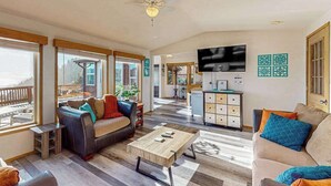 A spacious living area with a sofa, coffee table, and television.