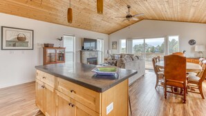 Une cuisine spacieuse avec des meubles en bois, un grand îlot central et un coin repas doté de chaises en bois.