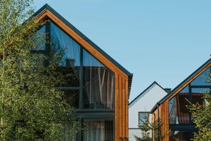 A modern building with large windows and wooden framing. - Luxury holiday home with terrace, sauna, jacuzzi (Niechorze)
