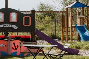 Ein Spielplatz mit einer Piraten-Spielanlage, inklusive Rutsche und Kletterelementen.