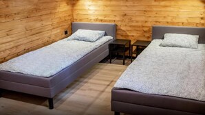 A room with two single beds, a small table, and a bench. - Luxury holiday home with terrace, sauna, jacuzzi (Niechorze)