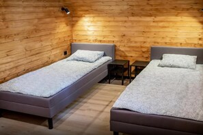 A room with two single beds, a small table, and a bench. - Luxury holiday home with terrace, sauna, jacuzzi (Niechorze)