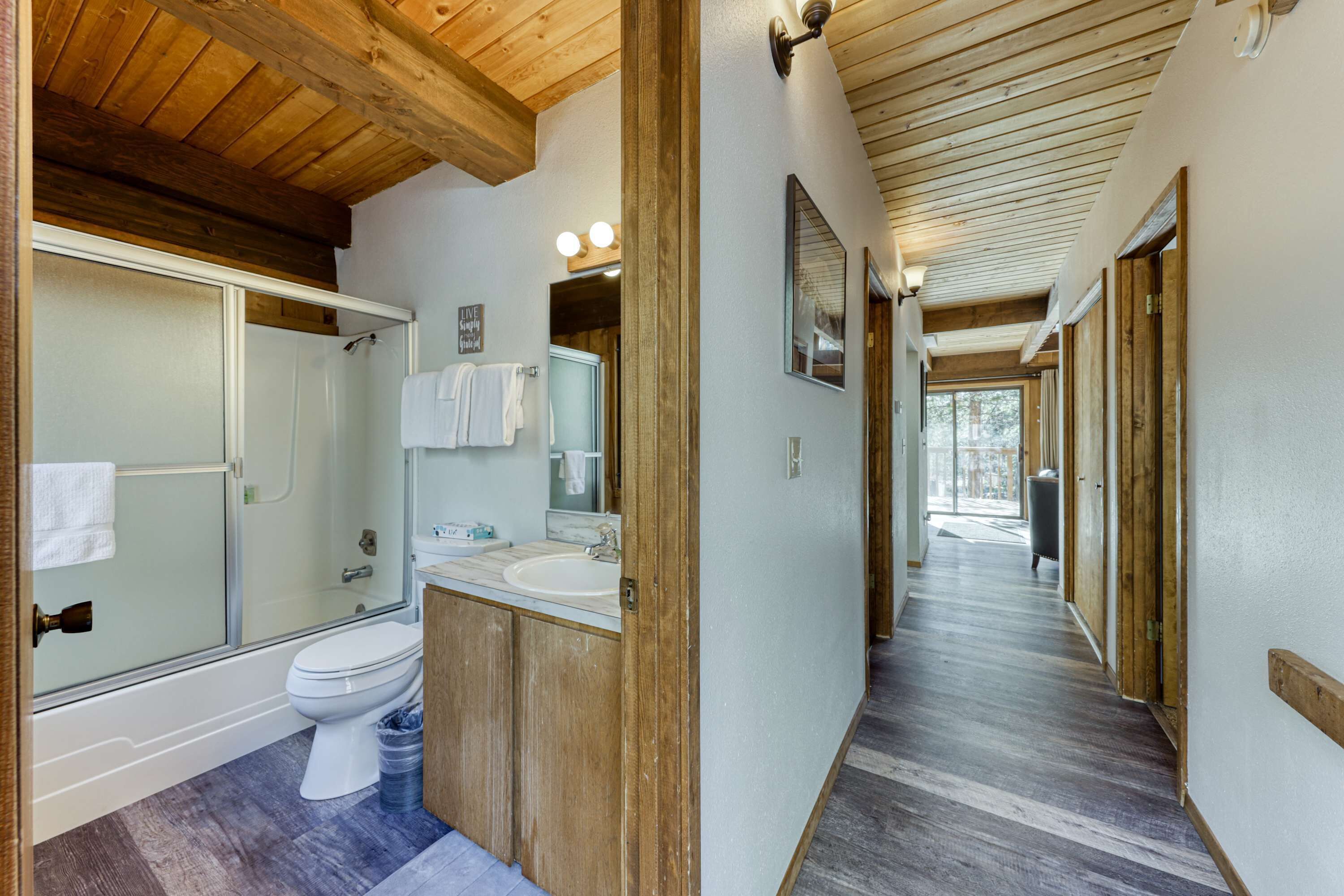 A bathroom with a shower, toilet, sink, and mirror.