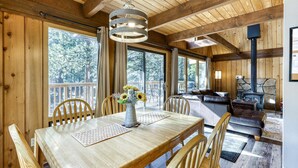 Un interior de madera con una mesa de comedor, sillas, un sofá y una chimenea.