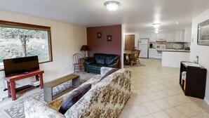 A living room with a sofa, a television, and a window. - Wonderful Home Close to Lake withPrivate W&D, WiFi, Gas Fireplace - 2 Dogs Okay (Joseph)