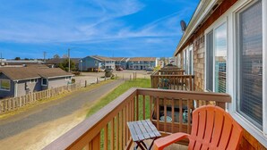 A residential area with a wooden deck, a red chair, and a view of neighboring houses. - Family Friendly Coastal Getaway Townhome Near Beach & Downtown (Long Beach)