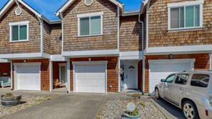 A row of two-story houses with attached garages, a driveway, and a parked car. - Family Friendly Coastal Getaway Townhome Near Beach & Downtown (Long Beach)