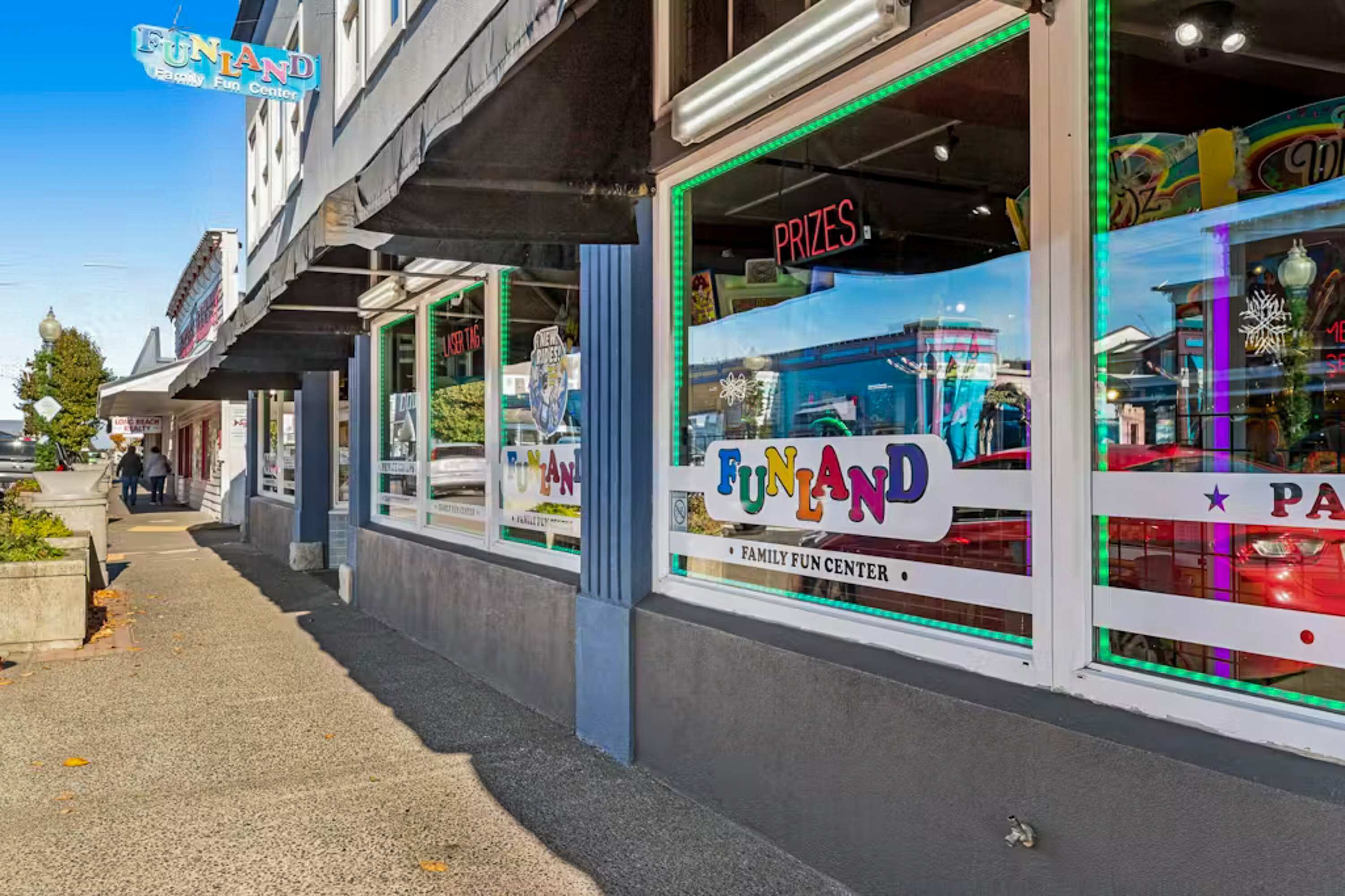 En butik med en skylt som visar texten ”FUNLAND – ett nöjescenter för hela familjen” och ordet ”PRISER”, synligt genom fönstret.