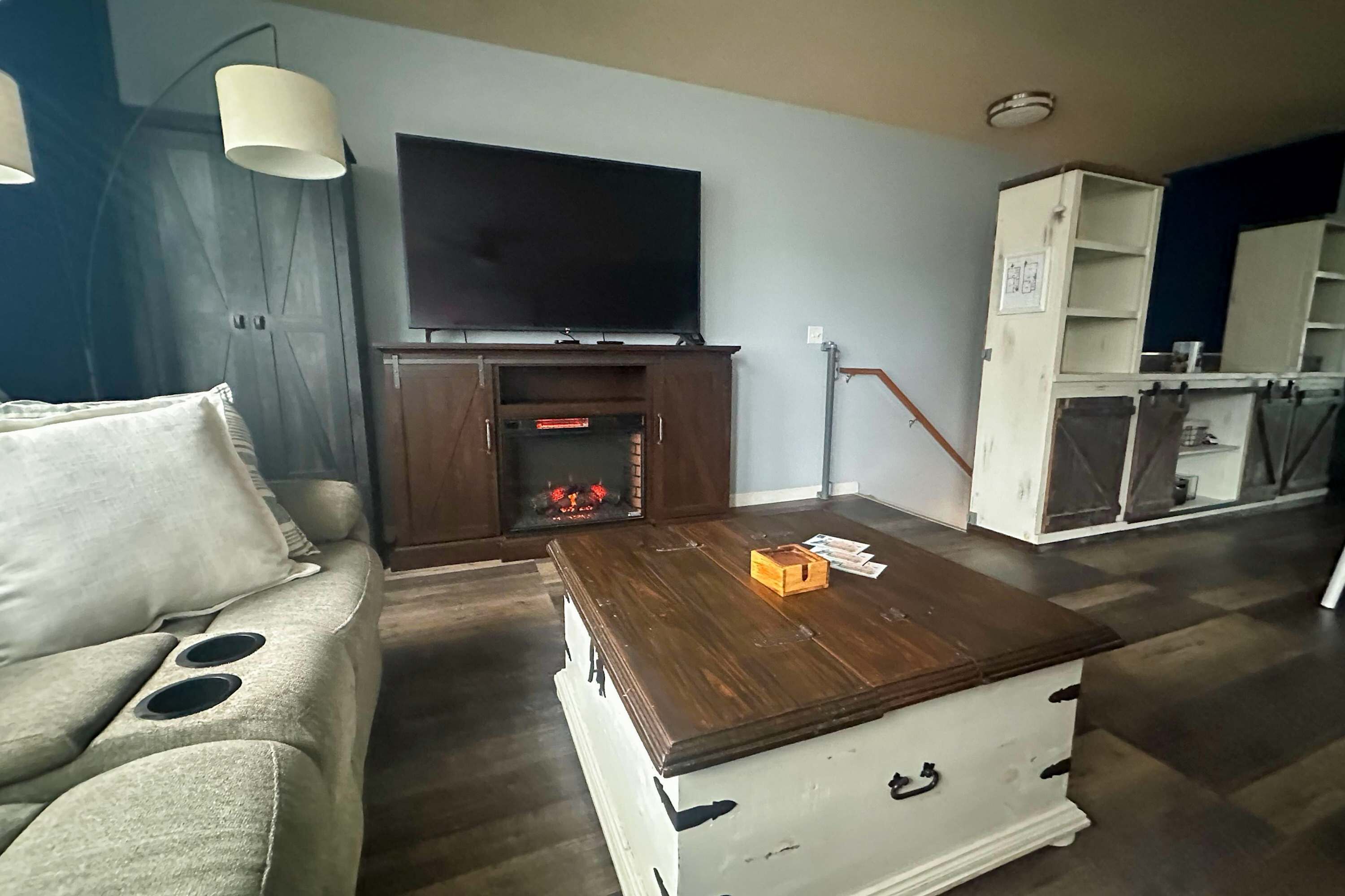 Een woonkamer met een bank, een salontafel, een televisie en een open haard.