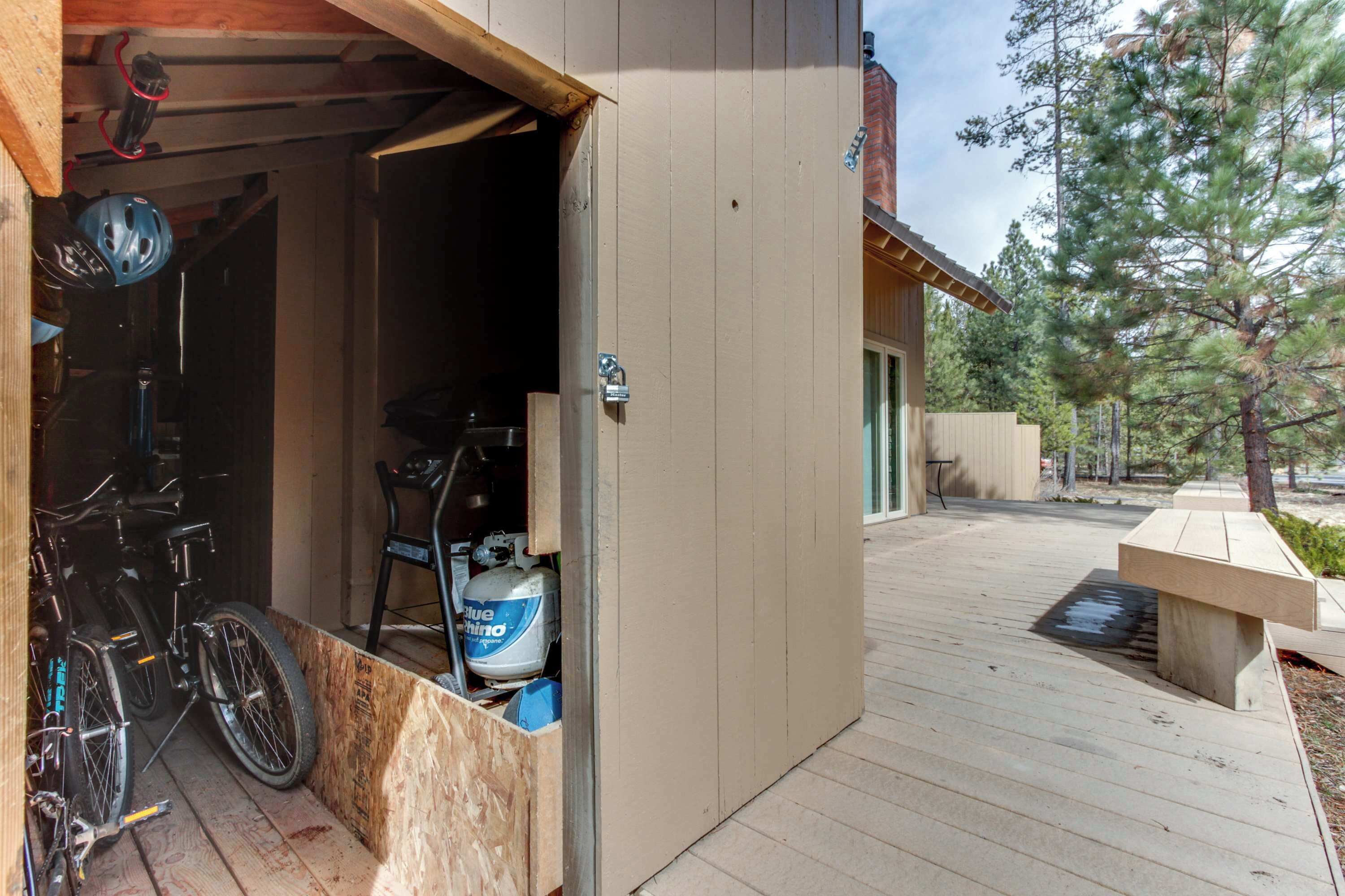 A wooden deck with a bike storage area, a water feature, and a bench.