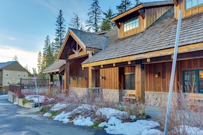 A wooden lodge with a stone foundation, wooden exterior, and a sloped roof.
