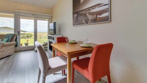 Un comedor con una mesa, sillas y un televisor.