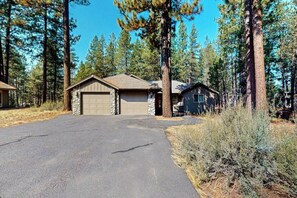 A residential property with a garage, a detached house, and a driveway. - Cozy home with private hot tub, patio dining, gas fireplace and full kitchen (Sunriver)