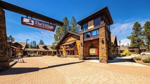 En stuga med en fasad av sten, träpanel på utsidan och en skylt med texten ”The Village at Sunriver”.