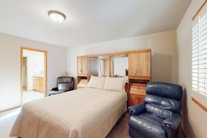 A bedroom with a bed, a chair, a wardrobe, and a mirror. - Cozy home with private hot tub, patio dining, gas fireplace and full kitchen (Sunriver)