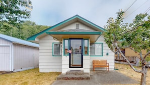 A small, single-story house with a front porch, a mailbox, and a bench. - Dog-friendly home with two full kitchens & a gas grill - walk to the ocean (Reedsport)