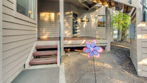 Une maison avec un porche, des marches en bois et des décorations florales.