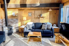 Ein gemütliches Wohnzimmer mit einer Couch, einem Couchtisch und einem Kamin.