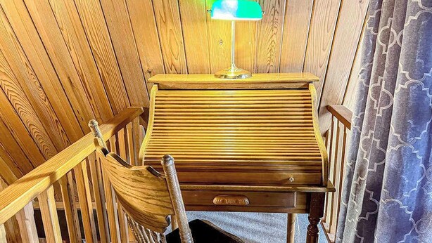 A wooden piano in a room with wooden walls and a patterned curtain. - Charming 2-story chalet with deck, wood stove, Deschutes River access (Sunriver)