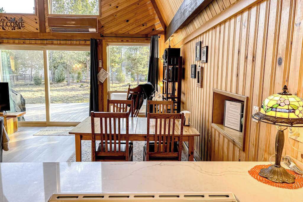 Un intérieur en bois comprenant un coin repas, une cheminée et une lampe en vitrail.